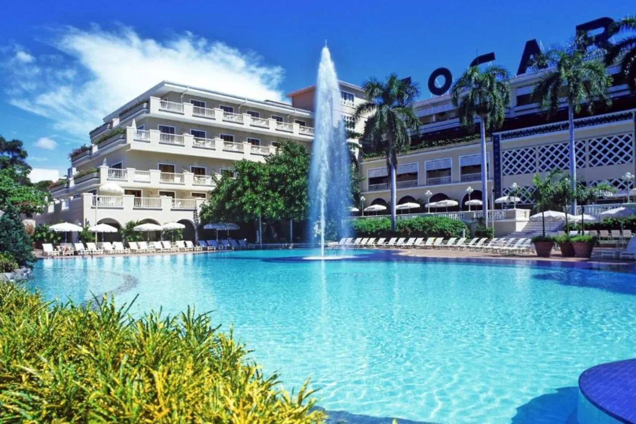 The turquoise pool and the main building of Hotel Tocarema, framed by palms